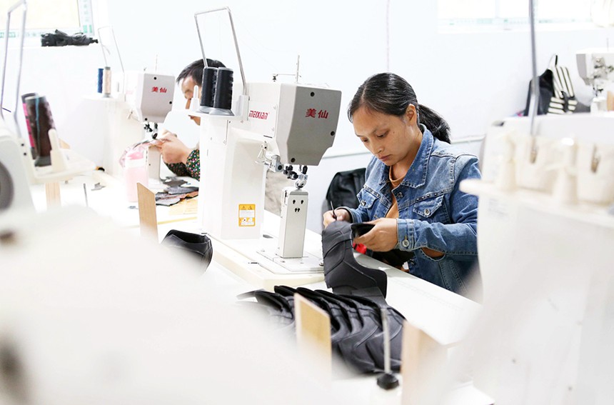 10月27日，女工在黔江區黃溪鎮親親制鞋廠縫制鞋幫。該鞋廠招收的50多名村民全部通過技能培訓，加工的鞋產品均為海外訂單。特約攝影 楊敏/視覺重慶