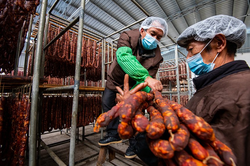 村民在寒冷中晾曬臘腸。?冉孟軍攝