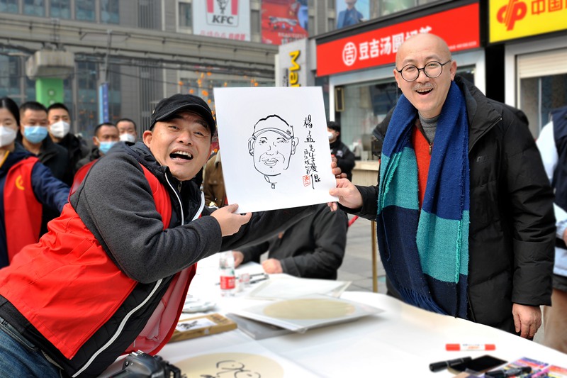 游江（右）為現場市民作畫。受訪者供圖