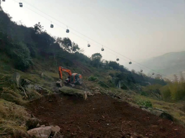 挖掘機在山坡上作業。周洪攝