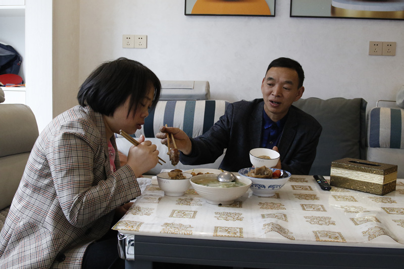 楊前海吃飯時為妻子陳長軒夾菜。楊夏麟攝