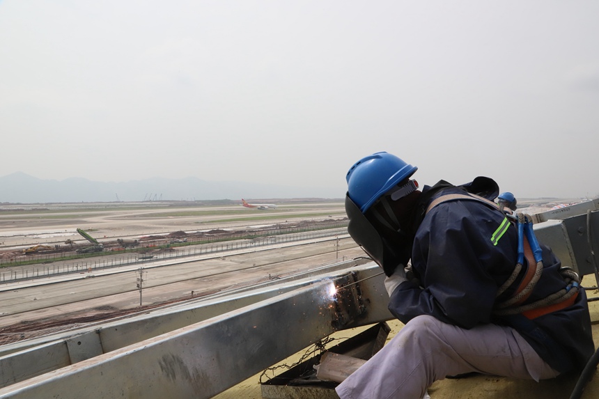 4月29日，工作人員在重慶江北國際機場T3B航站樓施工現場進行屋面施工。中建八局供圖