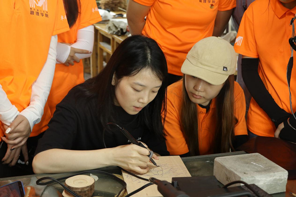 實踐團成員認真學習粘烙畫工藝。羅雨竹攝