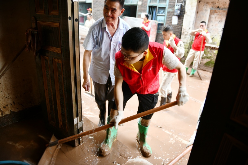 7月7日，國家電網紅巖（萬州營配）共產黨員服務隊幫助五橋居民清理淤泥。王倩攝
