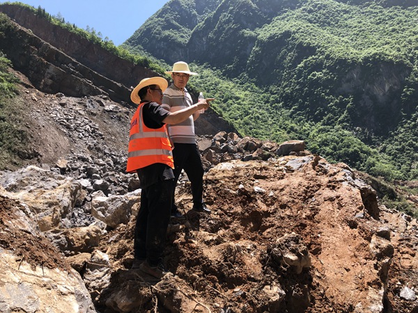 《身先士卒》。2022年6月30日，巫溪縣滑坡搶險工作中，炎炎烈日下 ，重慶市規劃和自然資源局地勘處處長李少榮（右）與208地質隊專業總工蔣先念現場討論滑坡搶險方案。黎中余攝