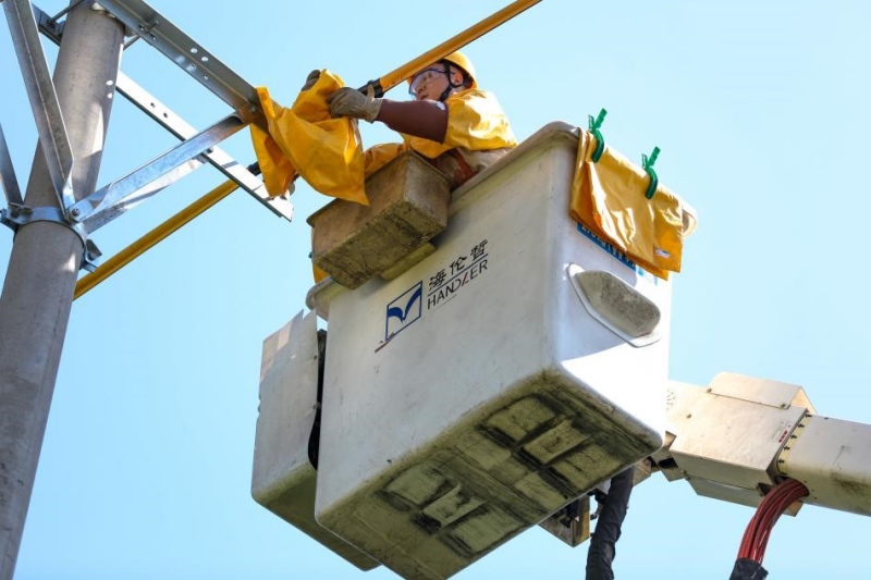 國網重慶市南供電公司帶電作業人員在進行橫擔的安裝。龔超攝