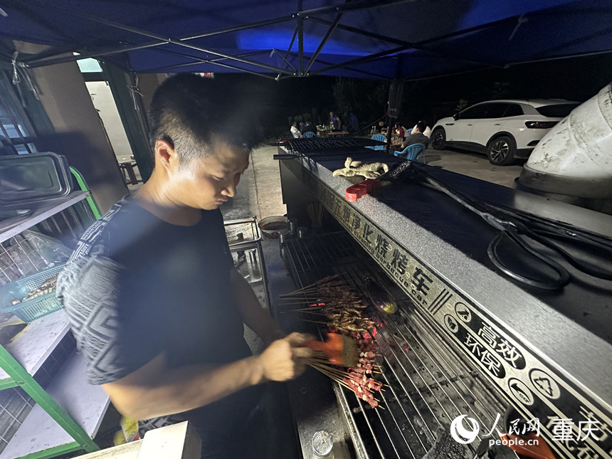 夜晚，方俊在農家樂為游客提供燒烤服務。 人民網記者 劉政寧攝