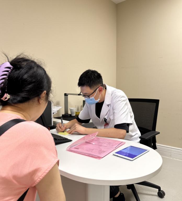 周明正在看診。院方供圖