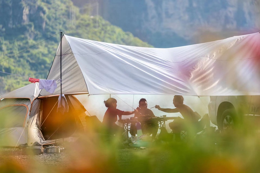 游客在頭渡鎮一露營基地避暑納涼。瞿明斌攝