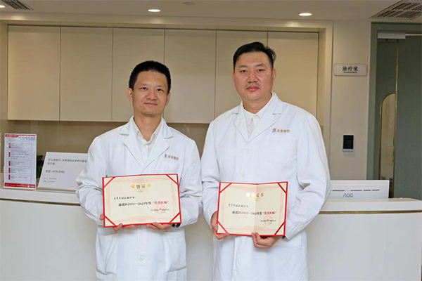 劉彥龍（左）、曹宇飛（右）展示“渝北區2023年度優秀醫師”證書。重慶星榮整形外科醫院供圖