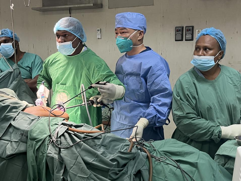 重慶醫生鮮鵬正在指導當地泌尿外科醫生Dr.Munguas主刀完成手術。受訪者供圖。