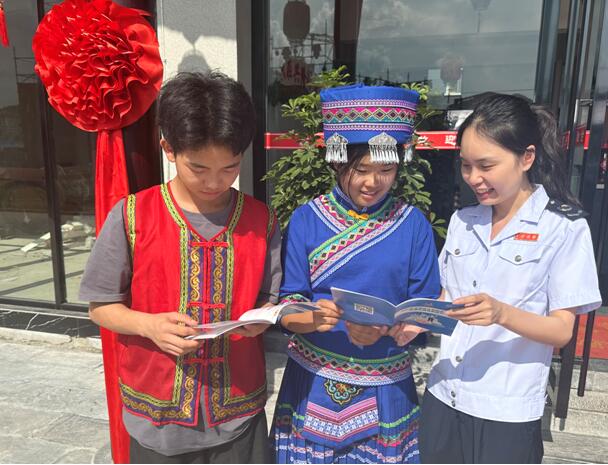 在中國長江“三峽涼都”（奉節）土家風情旅游文化節活動現場，奉節縣稅務局“詩橙稅音”服務隊正為商戶講解稅費政策。李春花攝