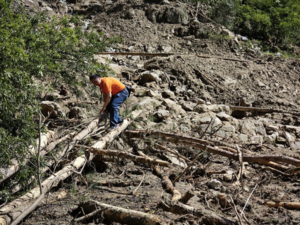 《烈日下的搶險救災地質人》。7月6日，南江地質專家黃永澤在萬州長灘鎮林場村皂角樹山洪泥石流搶險救災現場踏勘調查。廖學海攝