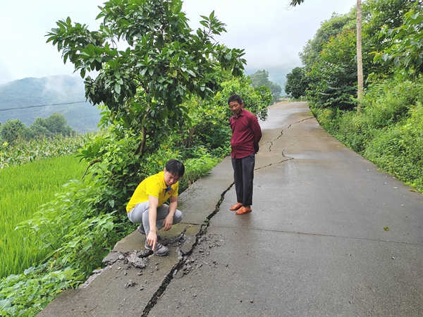 《為大地“診脈”，為安全“護航》。7月18日，接到開州區鐵橋鎮新龍塝滑坡發生強烈變形的電話報告，重慶地質礦產研究院開州區駐守地質工程師邱夢（左）到現場開展調查工作，分析研判滑坡穩定性情況。鄧朝松攝