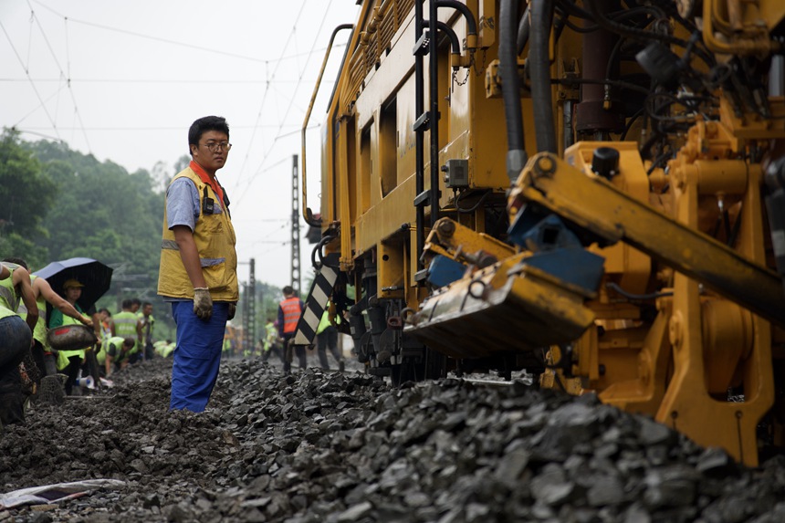 成都工務大機段職工在成渝線上指揮大機搗固。趙鵬攝