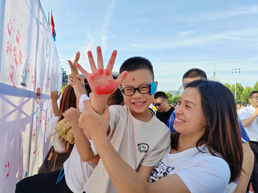 德福小學校一年級新生在心愿墻上按手印，許心愿。