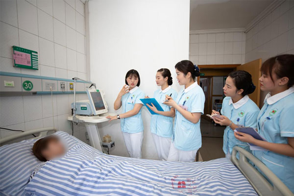 羅洪清（左一）帶領團隊查看患者身體指標。重慶市紅十字會醫院（江北區人民醫院）供圖