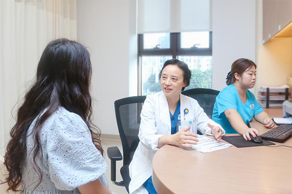 但陽（中）為患者進行診療。重慶安琪兒婦產醫院供圖