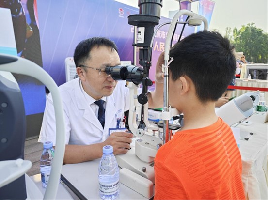 周自強為現場市民義診。重慶愛爾眼科醫院總院供圖