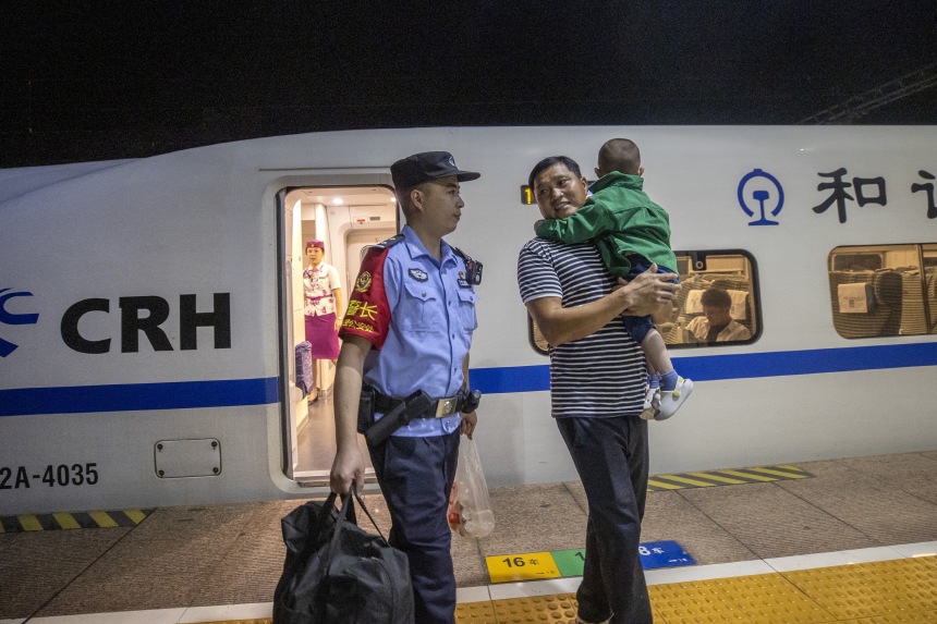 黃同川幫助旅客下車出站。胡勇攝