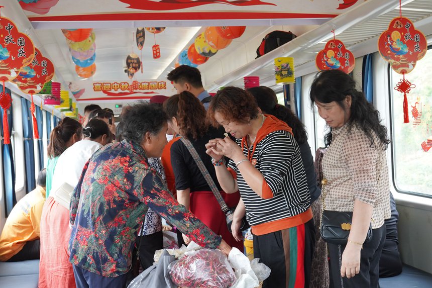 遵義開往重慶西的5630次列車上，旅客在集市車廂購買農產品。李文航攝