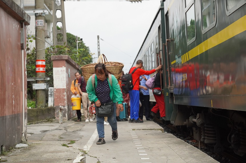 松壩站站臺，旅客背著農產品登上小慢車。李文航攝