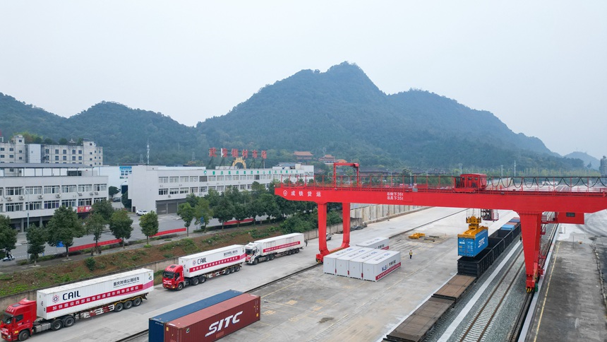 10月12日，秀山站貨場內，龍門吊正在將集裝箱吊裝至列車上。黃圯攝