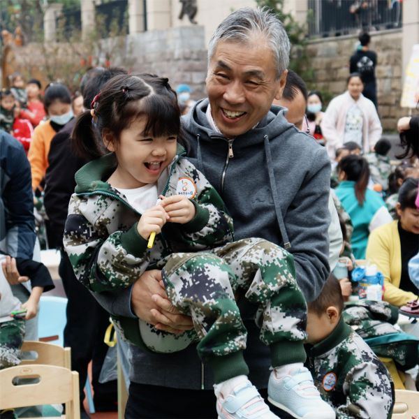 活動現場一位爺爺抱起了孫女。新絲路幼兒園供圖