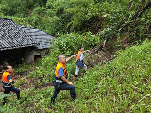 7月27日，市級專家盧丙清（中）、大足區地環站站長潘先衛（左）、南江地質隊唐銳（右），在“7.26”暴雨后趕赴大足區中敖鎮現場踏勘屋后垮塌情況。庹