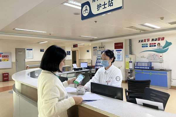 患者家屬在骨關節外科護士站辦理出院結算手續。重慶大學附屬江津醫院供圖