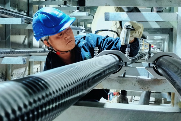 工作人員在安裝電纜抱箍。艾黎攝