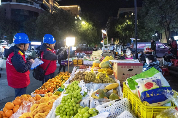 12月28日，國家電網紅巖（城口）共產黨員服務隊在城口縣步行街夜市攤點開展安全用電巡查。牟丹陽攝