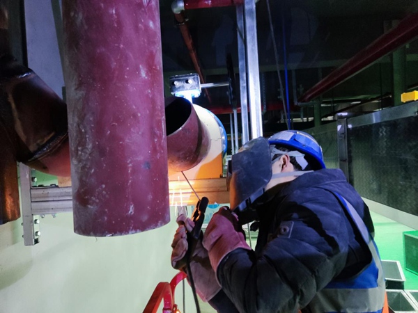 焊工李浩正在剪叉車上進行管道焊接。中建八局供圖