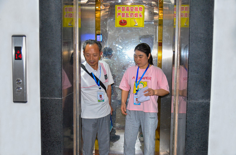 牌樓街道大河溝社區，物業長、樓棟長排查居民反映的電梯安全問題。付作僑攝