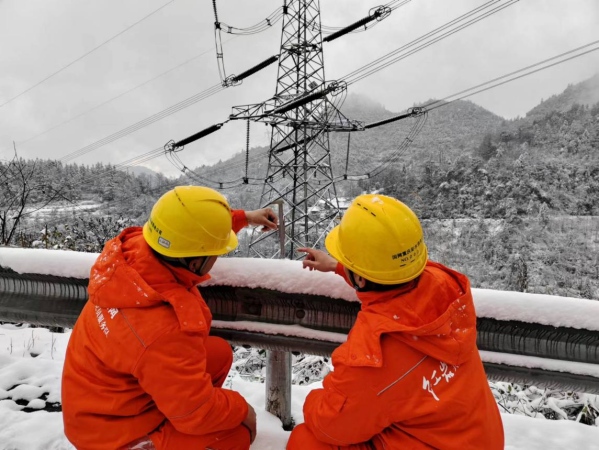 國家電網紅巖（彭水運檢）共產黨員服務隊隊員正在測積雪厚度。蔡光進攝