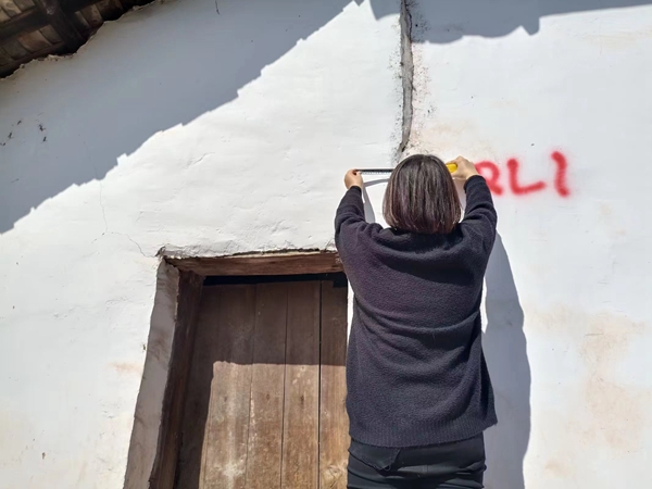 《守護者》（組圖）二。10月15日，駐守地質工程師李治偉、群測群防員王安然對兌窩子坪滑坡后新增監測點進行測量，觀察，記錄。劉勇攝