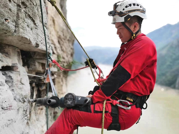 《懸崖鉆孔，安裝監測設備》。7月下旬，重慶地質礦產研究院派出的專業“蜘蛛人”開展高空作業，在奉節開展危巖隱患區域崖壁傳感器安裝工作，保障地質安全。鄧朝松攝