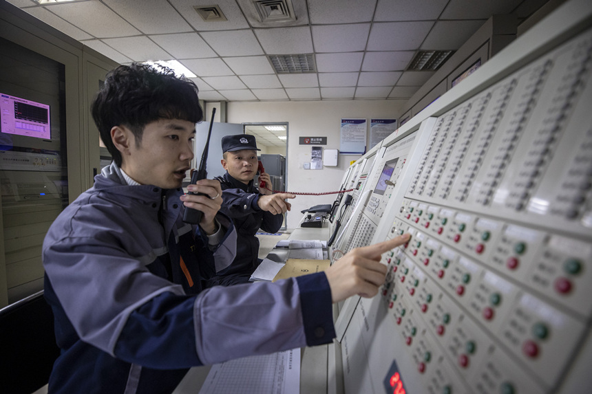 彭聰（右一）在重慶北站消防控制室工作人員的配合下，對車站消防信號設備進行測試。胡勇攝