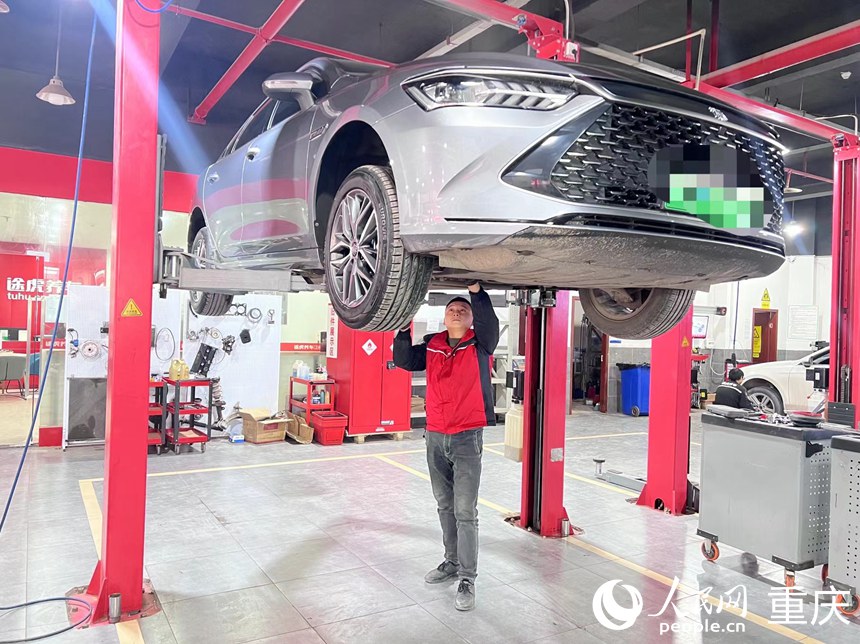 冉清兵在檢查新能源汽車底盤。人民網記者 胡虹攝