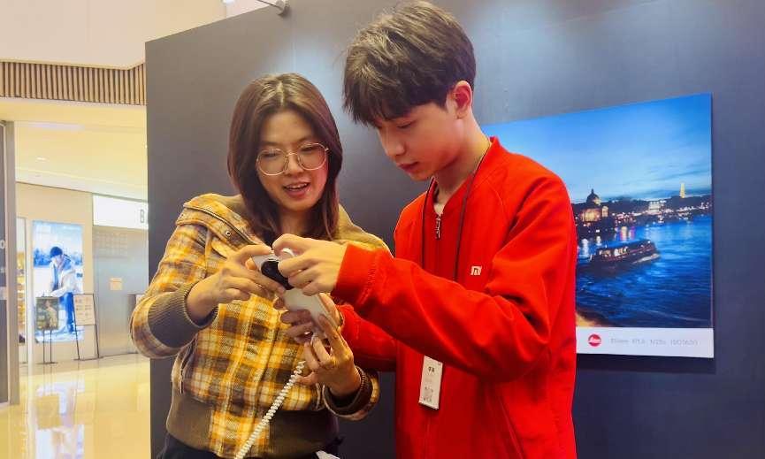 工作人員為市民講解手機AI功能。馬春鵬攝