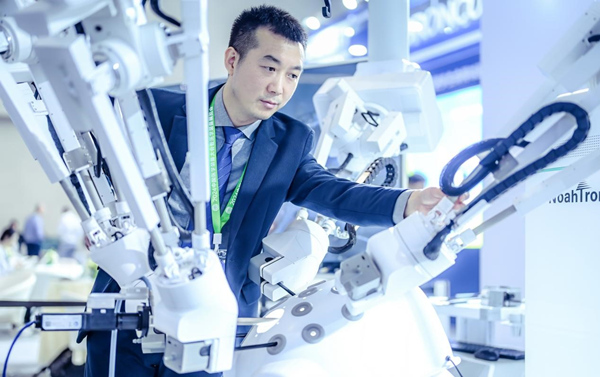 柏龍在展會現場查看五臂腔鏡手術機器人。謝朝欽攝