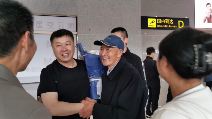 唐啟明在機場與親人共敘親情。重慶合川區公安分局供圖