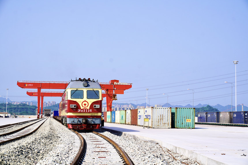 4月28日，重慶涪陵龍頭港，一列搭載著精己二酸、聚酯切片等貨物的西部陸海新通道集裝箱班列緩緩駛出。涪陵車務段供圖
