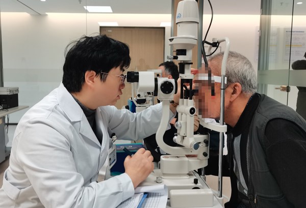 張曉城為患者檢查術后視力情況。重慶南坪愛爾眼科醫院供圖