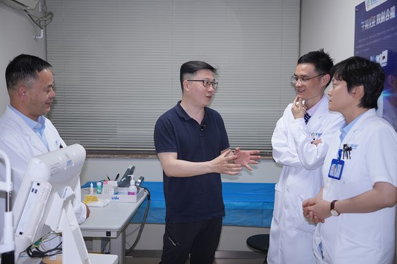 何勇（左二）與醫生探討科AI的應用。重慶普瑞眼科醫院供圖