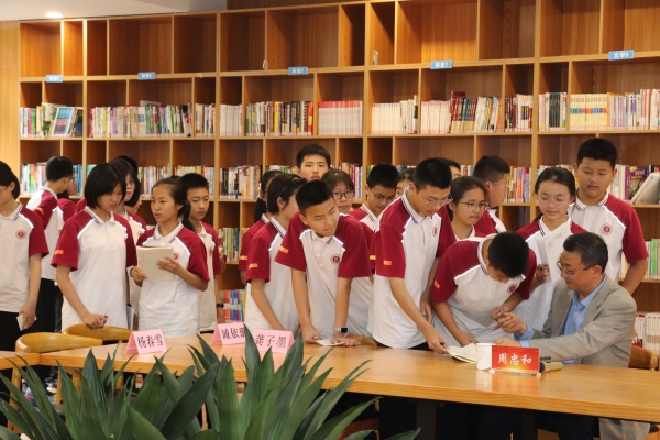 周忠和為重師附中的學生們簽名。重慶師范大學供圖