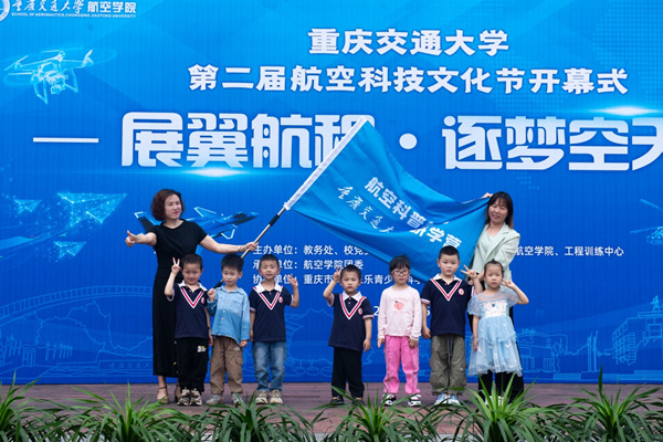 該校航空學院黨委書記舒琳為來自雙福巴蜀實驗幼兒園的小朋友代表授旗。重慶交通大學供圖