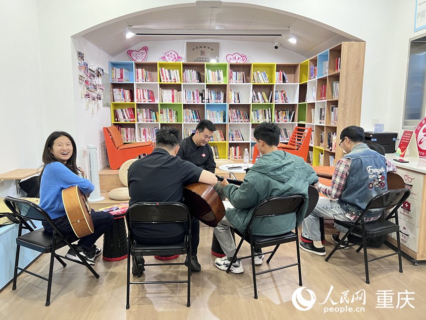 觀音橋街道九街新時代文明實踐市級示范點夜校，學員們正在學習吉他課。 人民網記者 胡虹攝