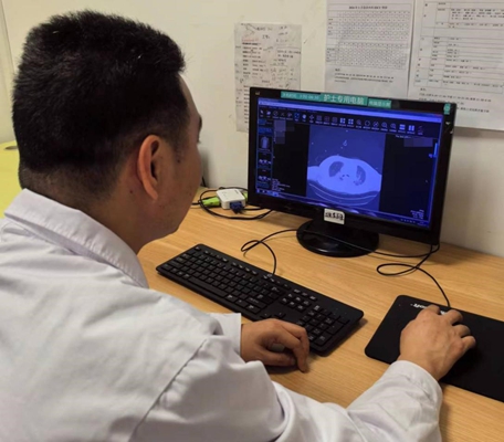 王曉龍查看患者的肺部CT檢查結果。重慶醫科大學附屬第二醫院供圖