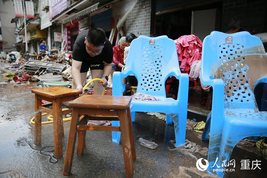 洪水消退后，居民正在清洗被洪水浸過的物品。人民網記者 劉政寧攝
